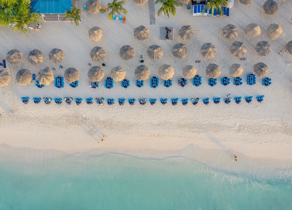 Vista aérea de una playa con filas de reposeras azules