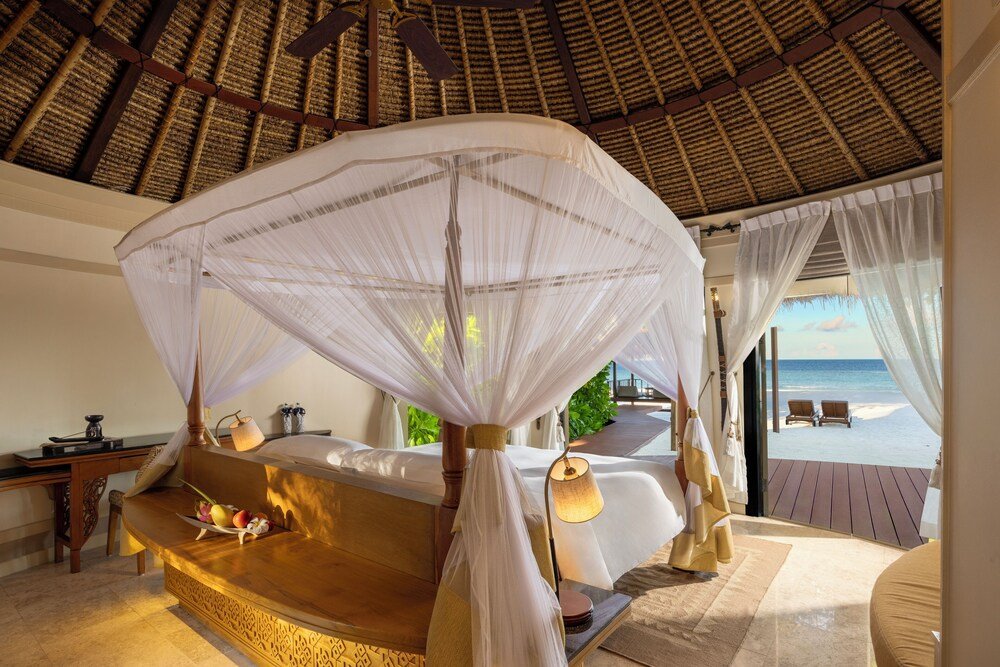 Bedroom with a canopy bed and a view of the beach