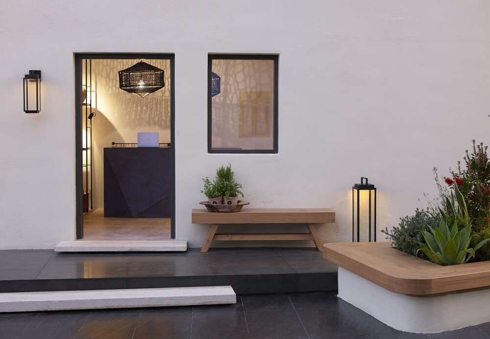 Entrada moderna con un banco de madera y una planta