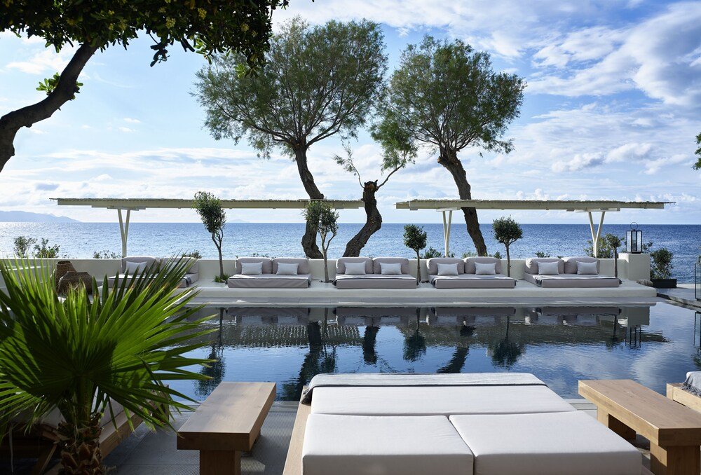 Zona de piscina con reposeras y una pérgola