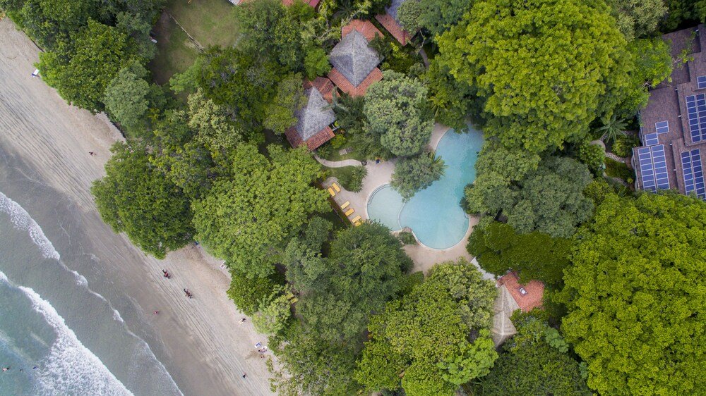 Vista aérea del resort con la piscina junto a la playa