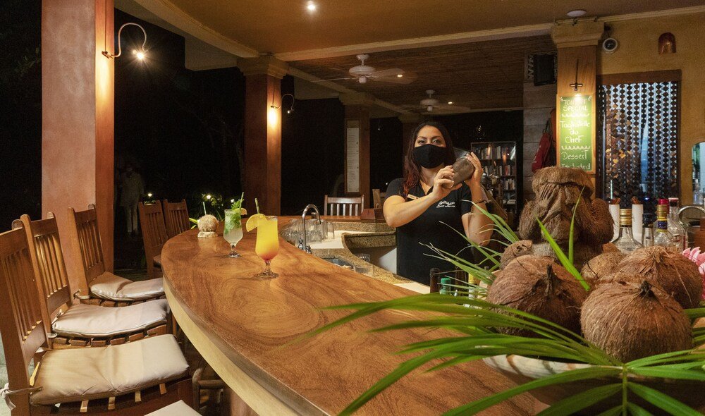 Bar con barra de madera y sillas en Capitán Suizo