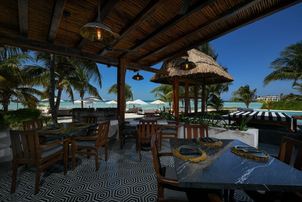 Comedor al aire libre con muebles de madera en Casa del Jaguar, Isla Mujeres