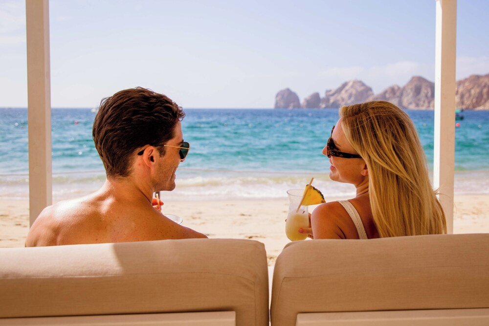 Couple sitting on beachside chairs facing the ocean at Casa Dorada