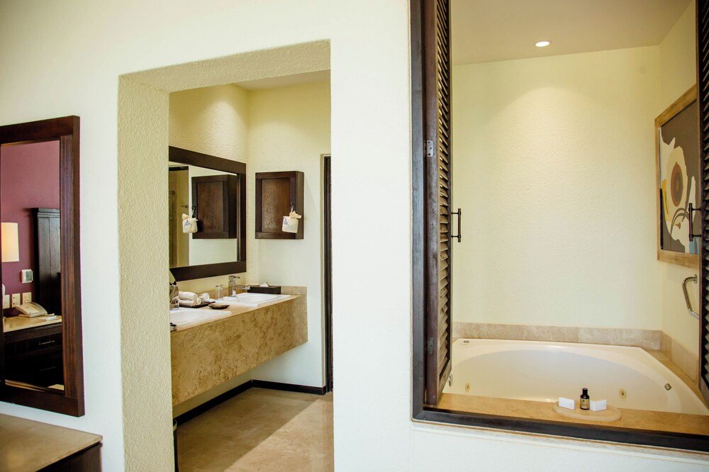 Bathroom with a bathtub, sink and mirror at Casa Dorada Los Cabos