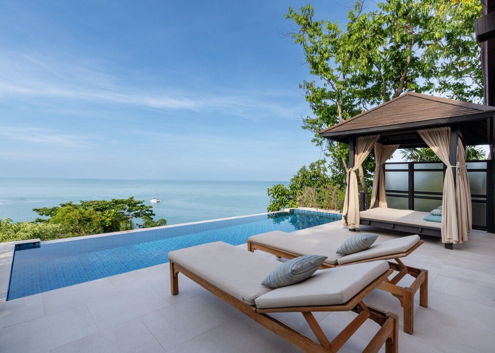 Poolside area with two lounge chairs and a canopy at Tongsai Bay