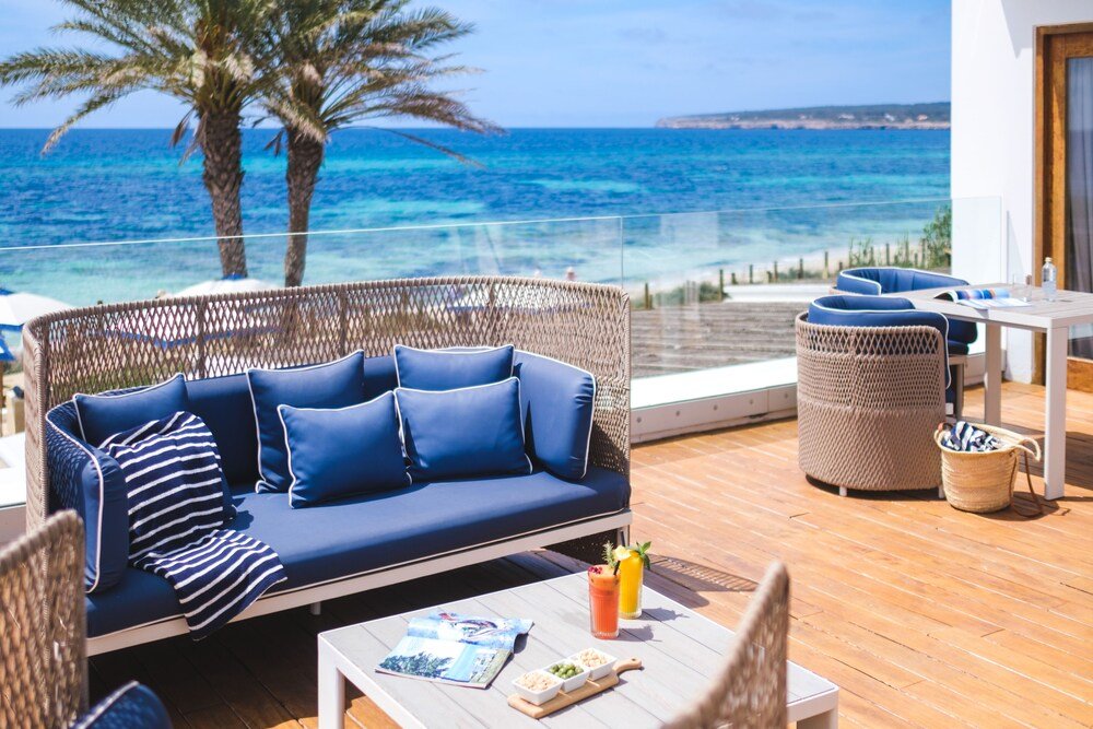 Balcony with a wicker sofa and chairs at Gecko Hotel & Beach Club