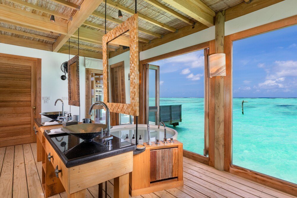 Interior de madera con una gran ventana hacia el mar