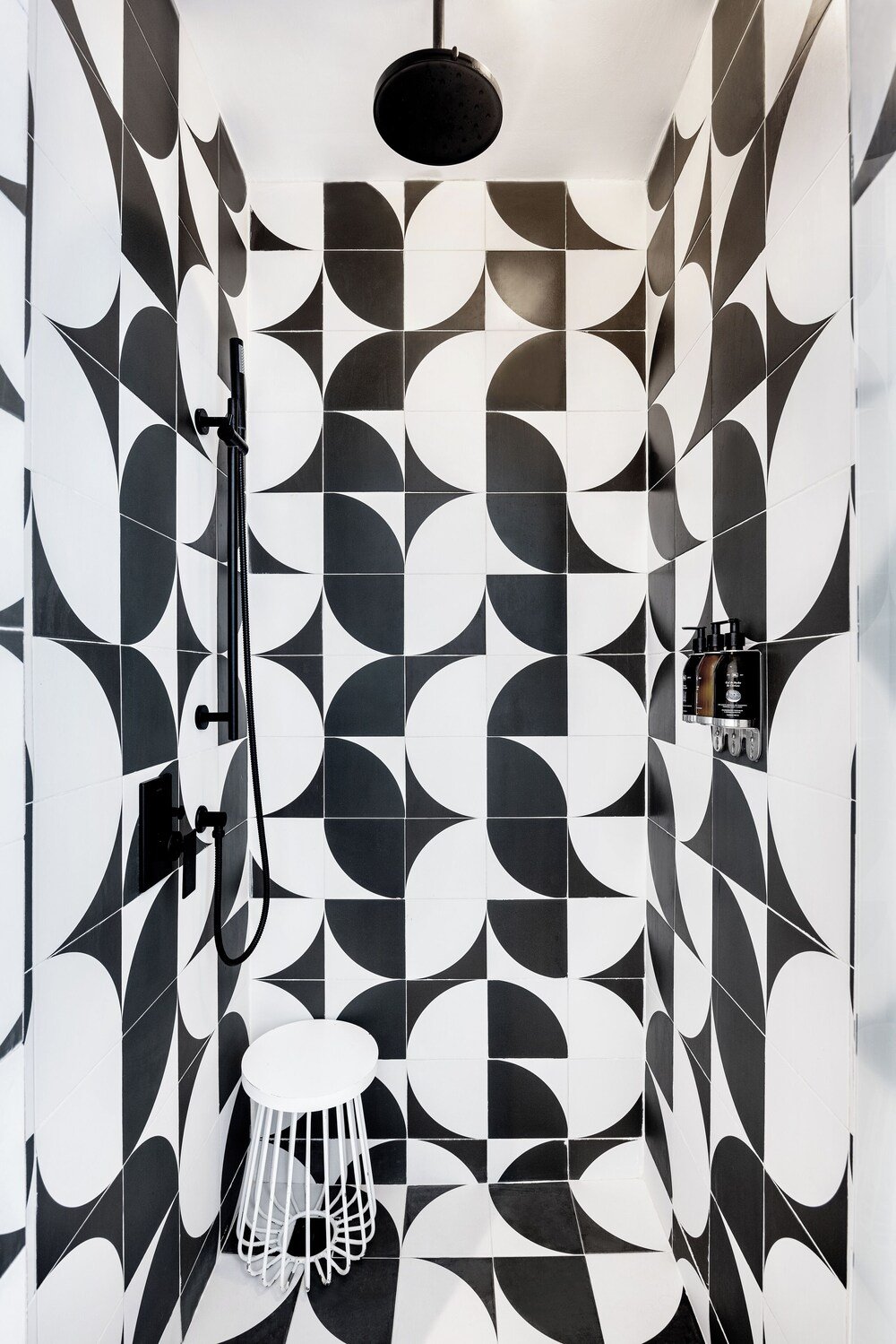 Baño con un patrón geométrico de azulejos blancos y negros