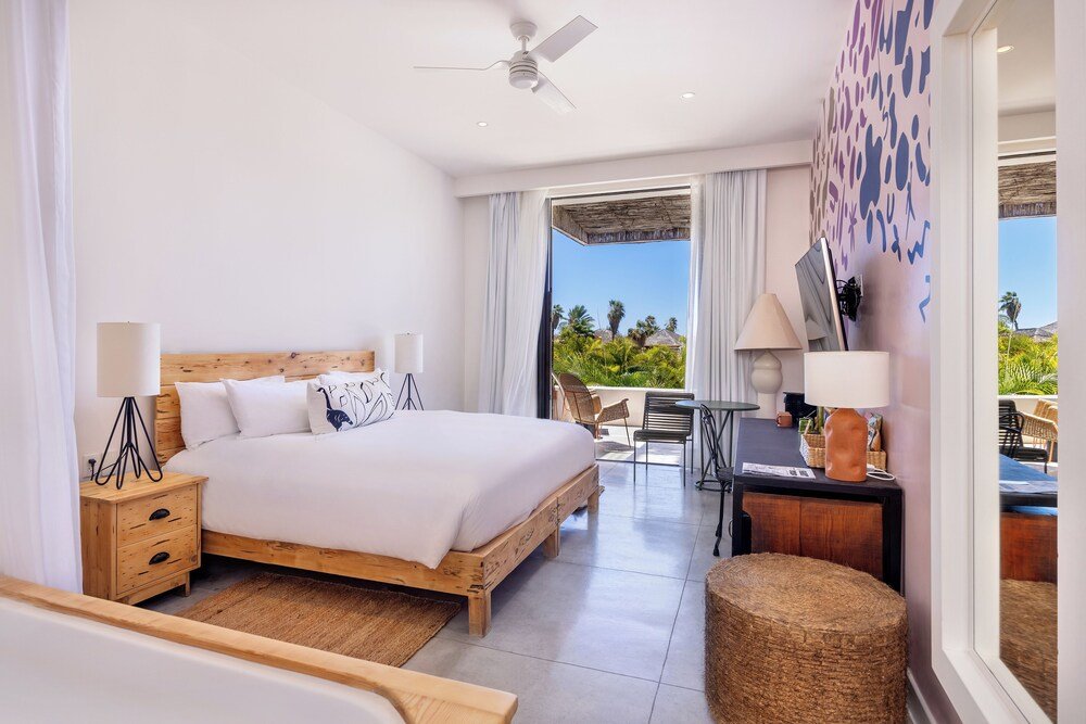 Zona exterior soleada con una silla de mimbre y un jacuzzi