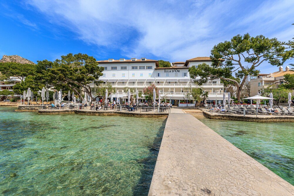 Waterfront hotel with clear blue water and outdoor seating