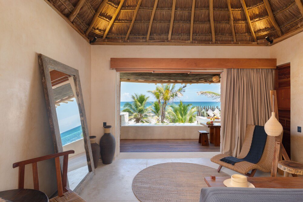 Habitación con vista al mar, techo de palma y reposera