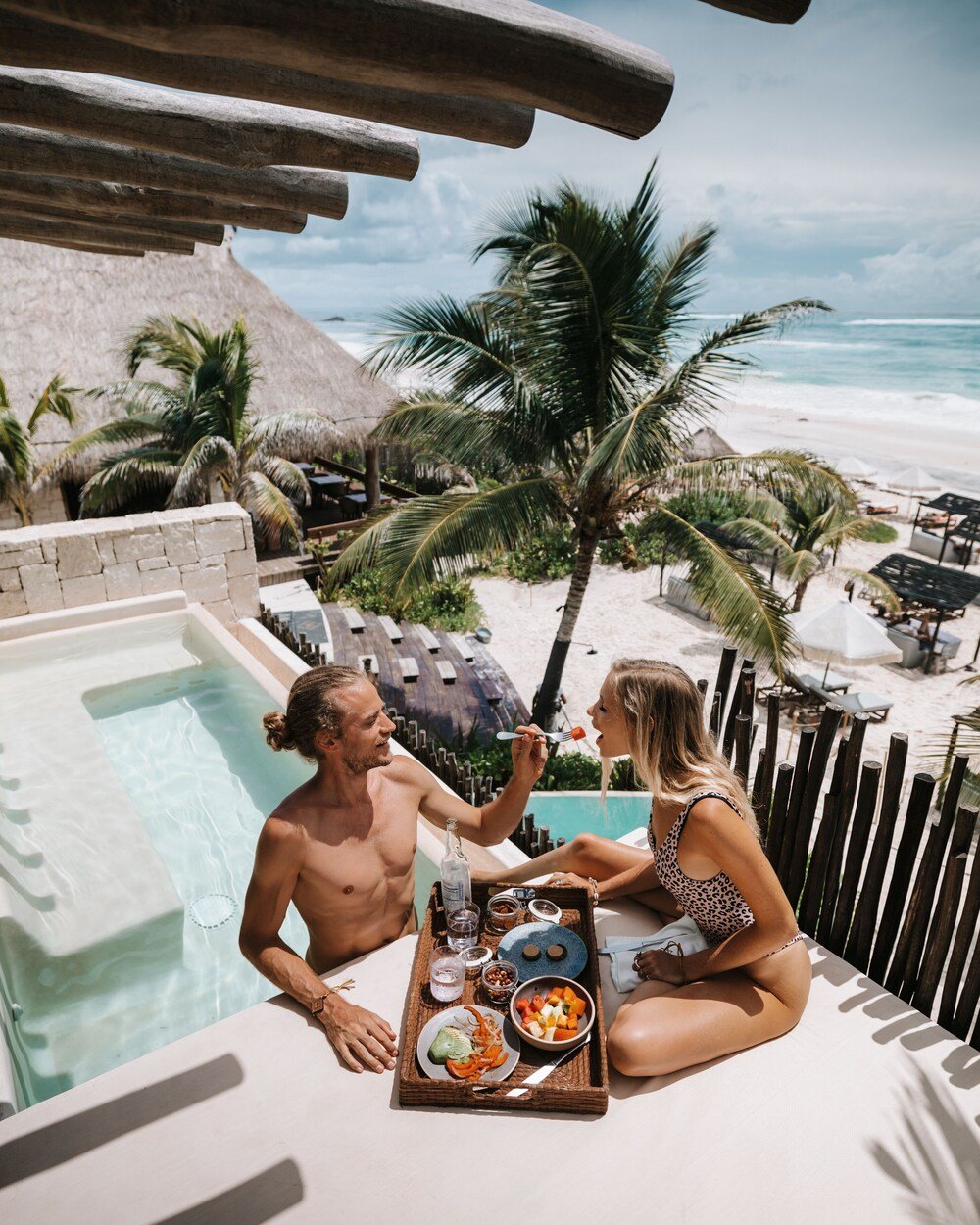 Pareja cenando junto a una piscina con vista a la playa