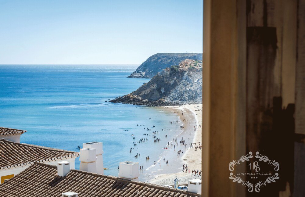 Vista costera con playa y acantilados rocosos