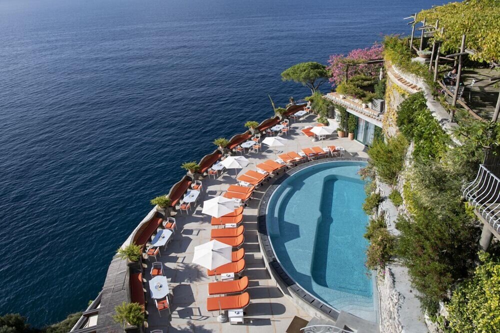 Zona de piscina con reposeras y sombrillas