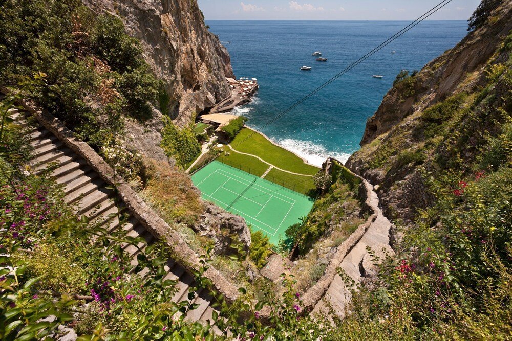 Cancha de tenis rodeada de acantilados rocosos
