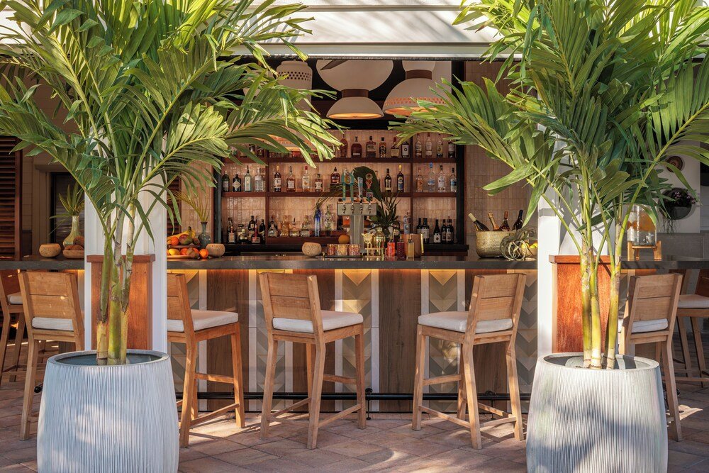 Zona de bar con barra de madera y taburetes