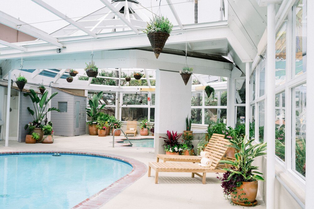 Zona de piscina cubierta con una reposera de madera
