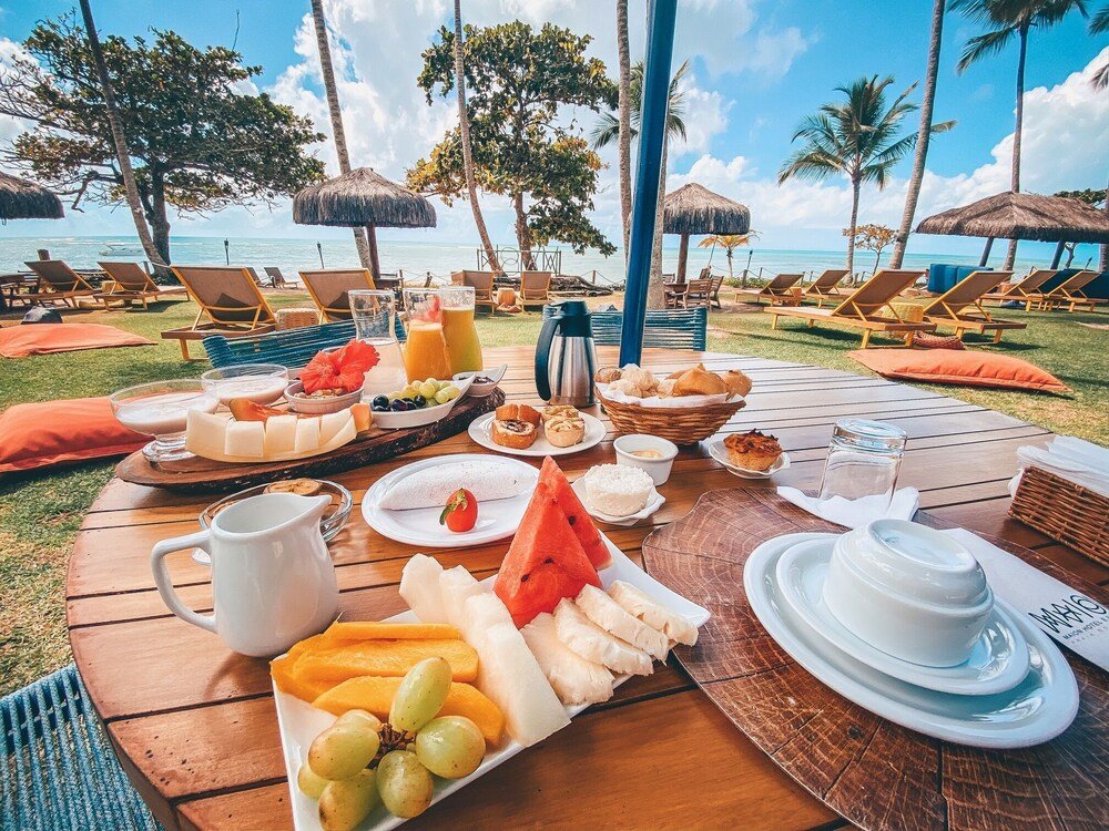 Desayuno buffet sobre una mesa de madera con fruta tropical