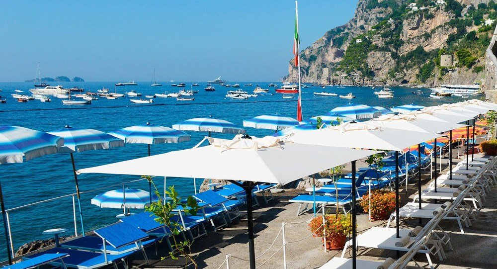 Coastal area with rows of sunbeds and umbrellas
