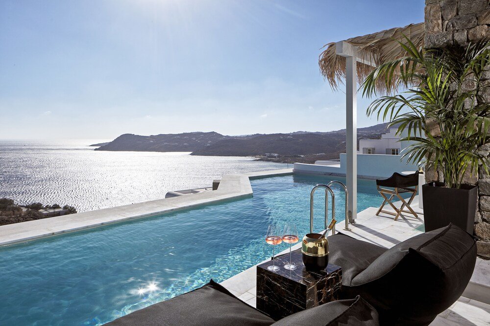 Poolside area with a view of the sea and a lounge chair