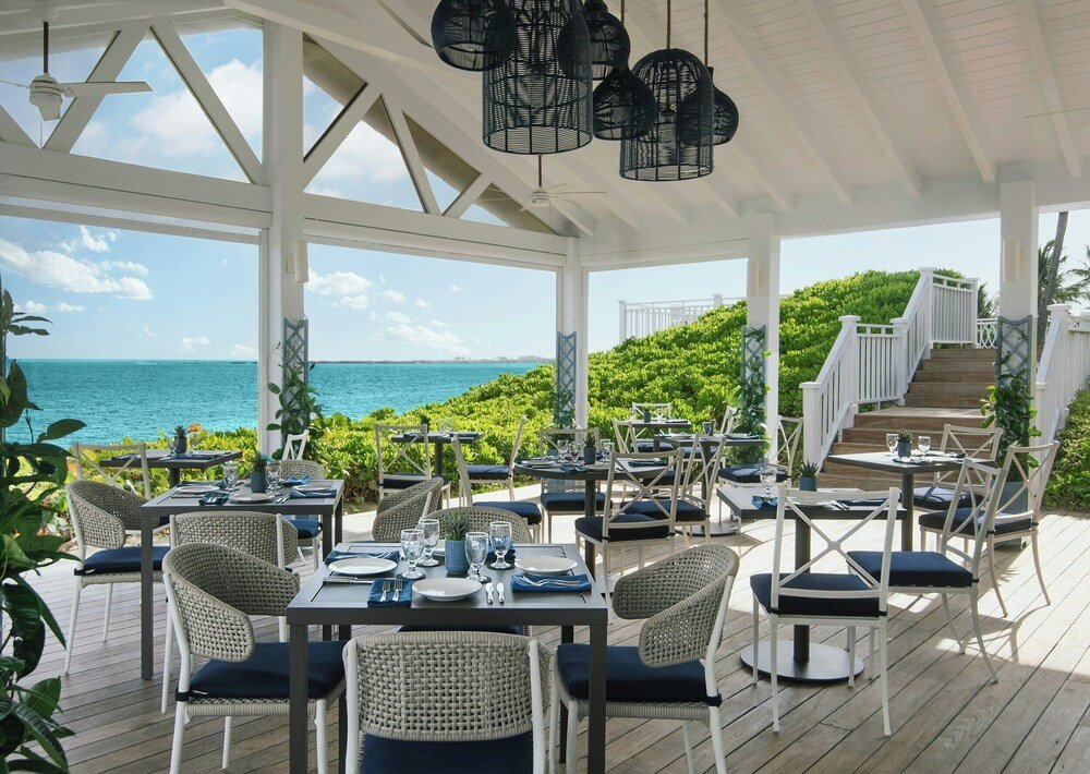 Comedor al aire libre con mesas frente al agua