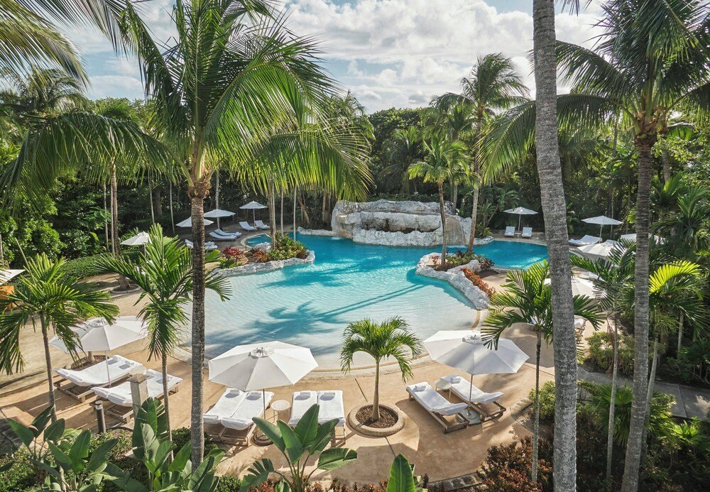 Zona de piscina del resort con reposeras y sombrillas