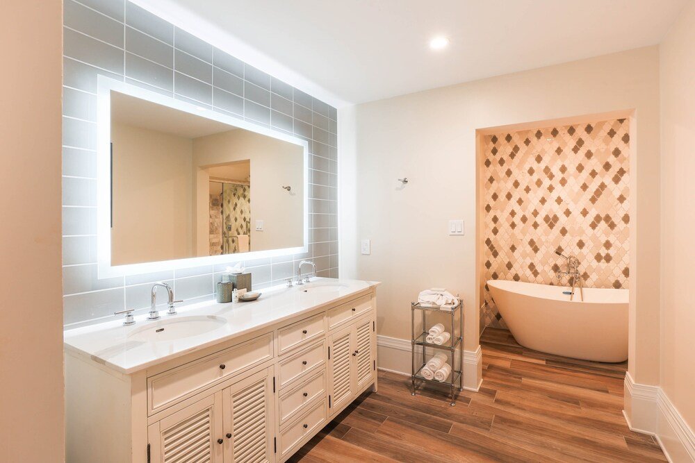 Baño moderno con un gran tocador y bañera exenta