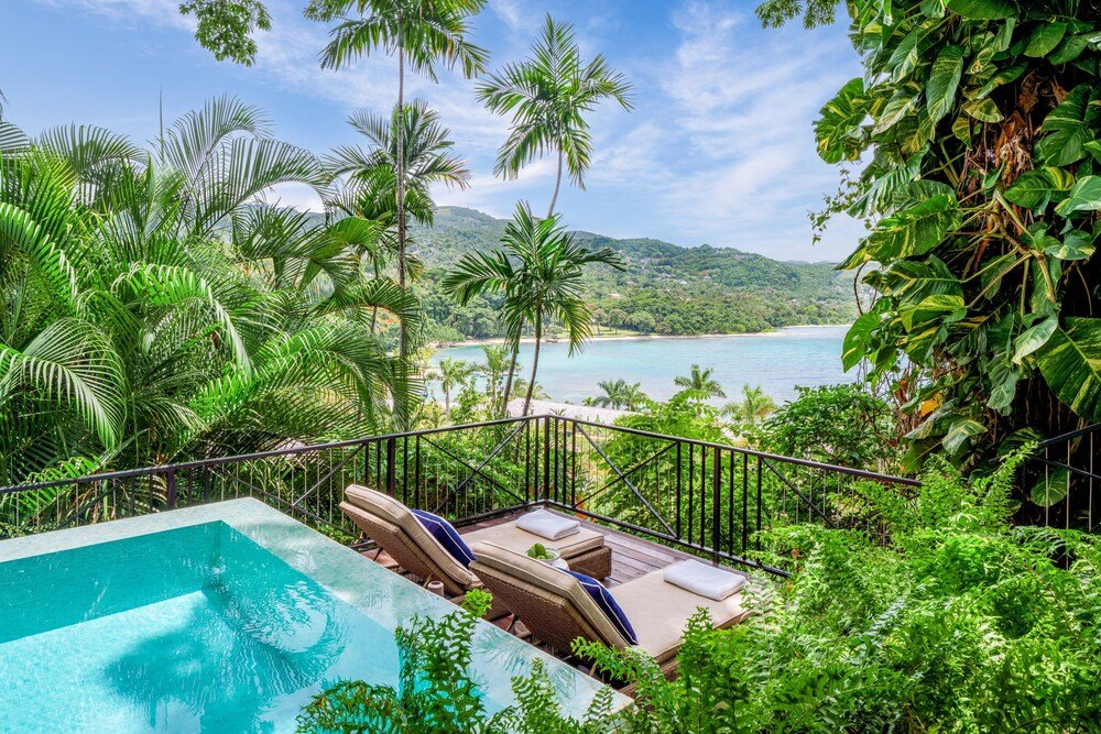 Poolside area with lounge chairs and an ocean view at Round Hill, Montego Bay