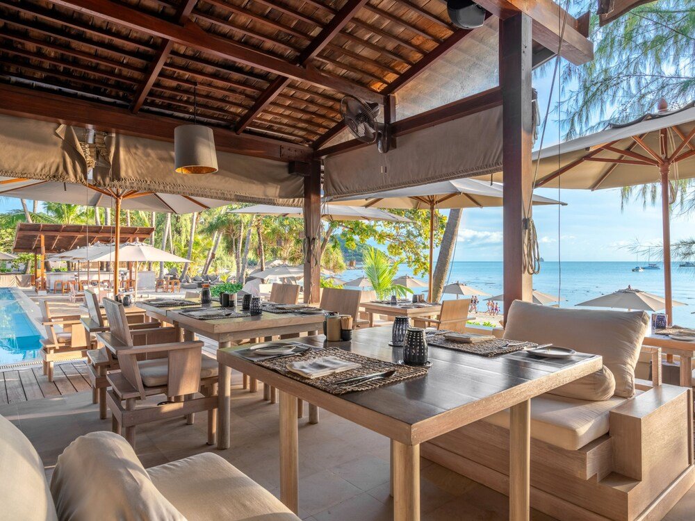 Comedor al aire libre con mesas y sillas de madera