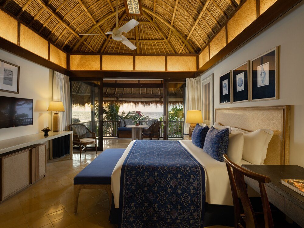Habitación del hotel con cama, mesa de luz y lámpara