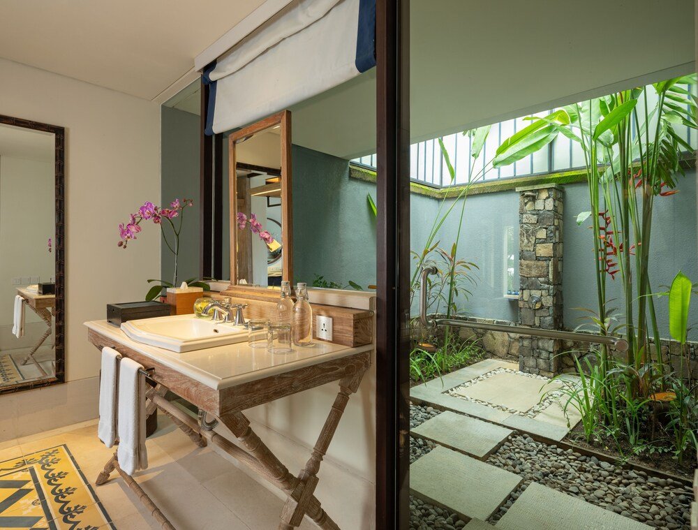 Baño con tocador de madera y un gran espejo