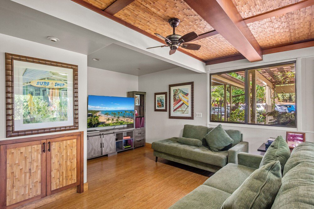 Sala de estar con un sofá verde y muebles de madera