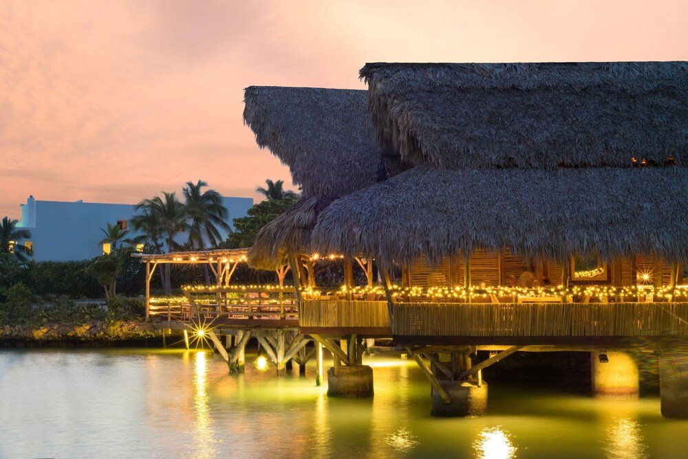 Thatched-roof bungalow with a wooden deck over the water